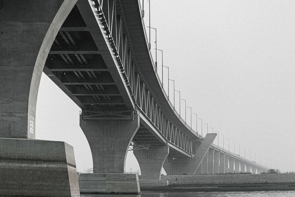 A sleek, modern architectural bridge connecting two land masses, representing the strategic framework needed to scale AI technology across a school district.
